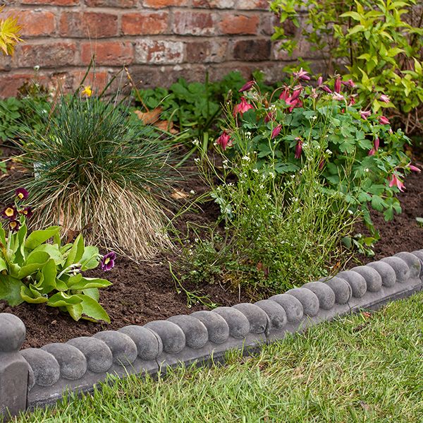 black rope edging bordering a newly planted flower bed 