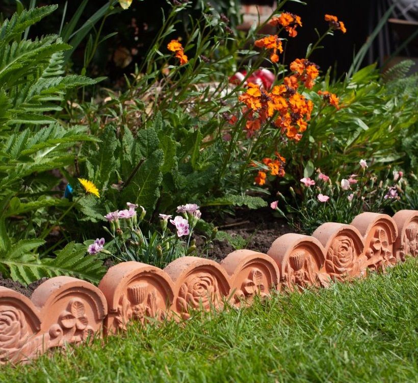 terracotta patterned border edging with colourful flower bed 